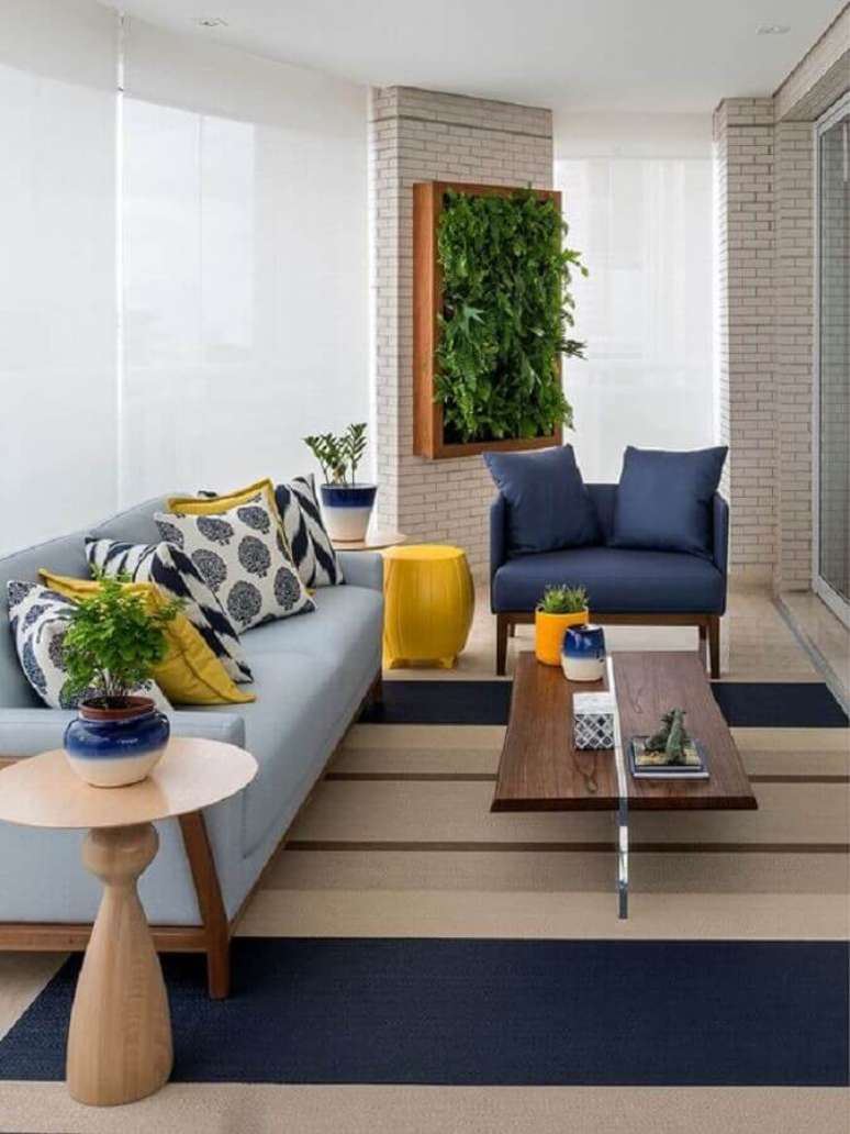 54. Tapete listrado para decoração de varanda de apartamento com poltrona e sofá azul – Foto: Casa de Valentina
