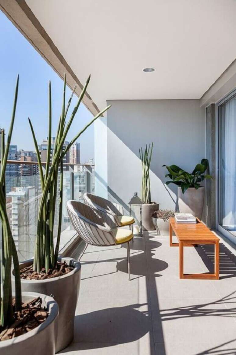 57. Varanda de apartamento decorada com banco de madeira e poltronas modernas &ndash; Foto: Casa de Valentina