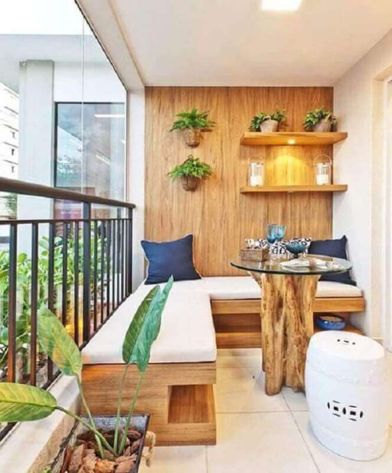 63. Varanda de apartamento decorada com sofá de canto e mesa pequena rústica – Foto: Pinterest