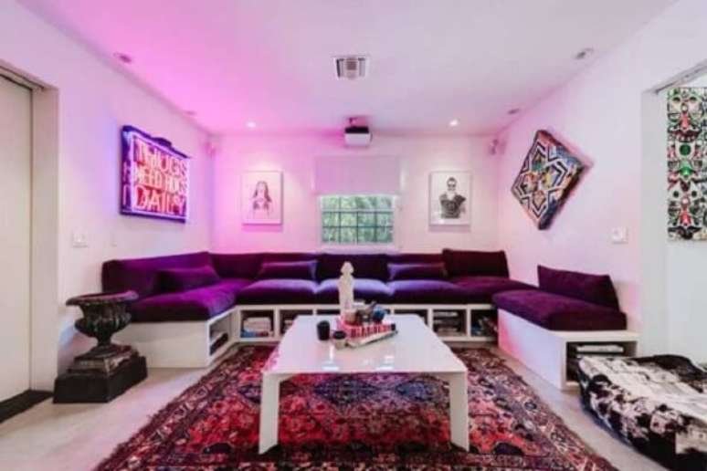 10. A luz embutida rosa traz uma atmosfera ousada combinada ao sofá roxo. Fonte: Pinterest