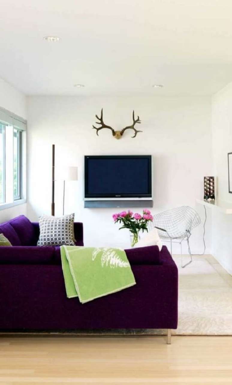 47. A manta para sofá roxo na cor verde traz um contraste interessante. Fonte: Pinterest
