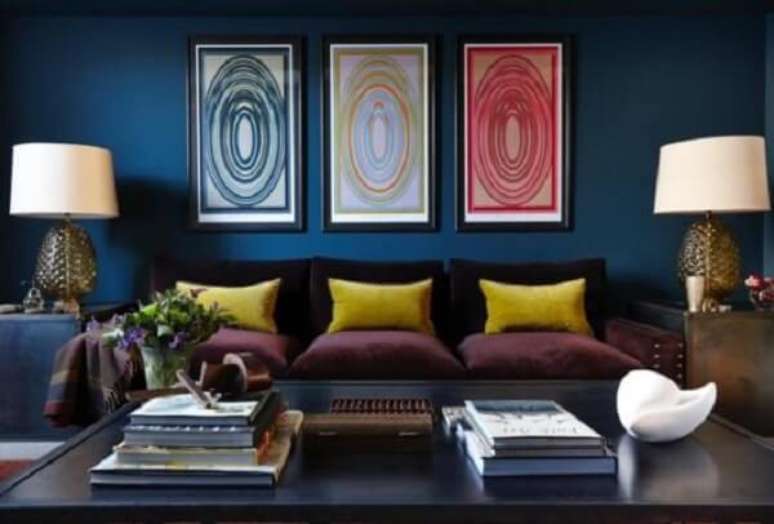 15. As almofadas amarelas sobra o sofá roxo trazem luz para a decoração. Fonte: Pinterest