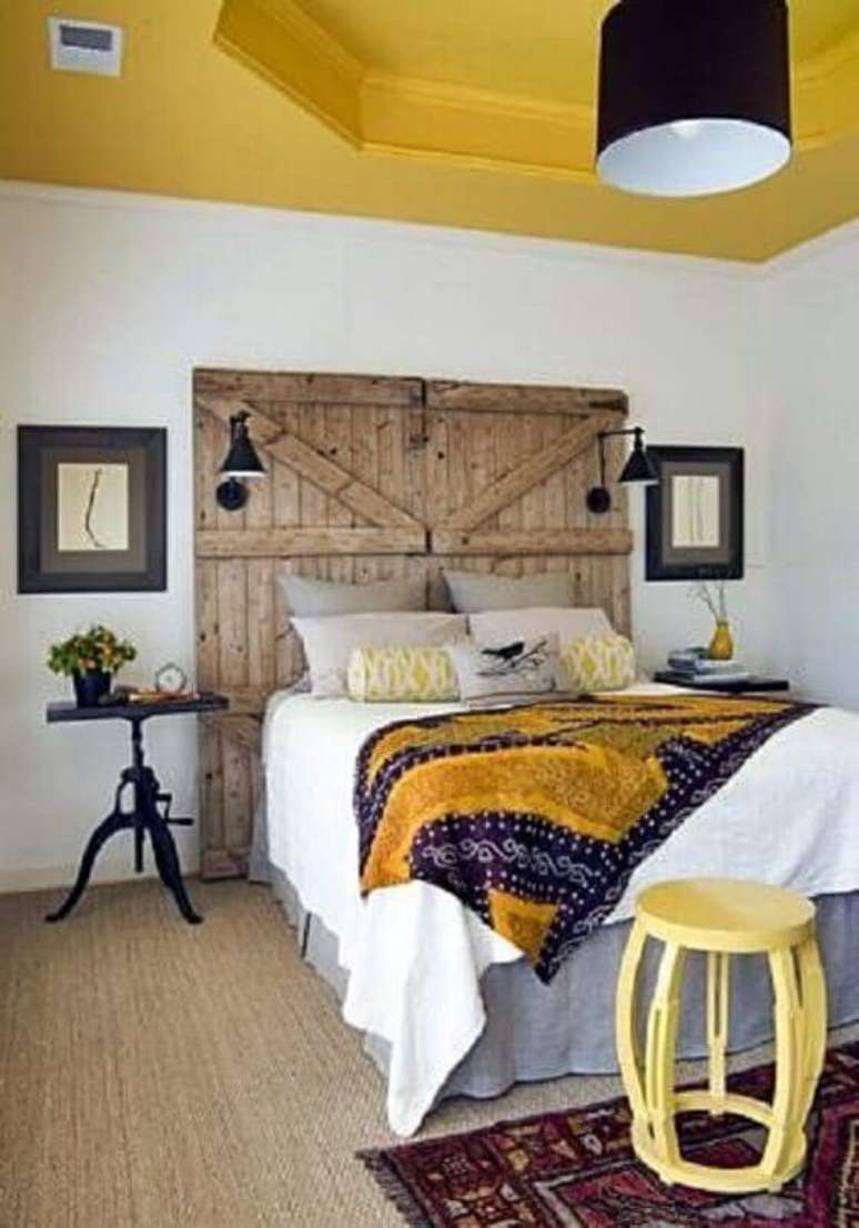 23. Decoração simples com mesa de canto para quarto com cabeceira rústica – Foto: Simples Decoração