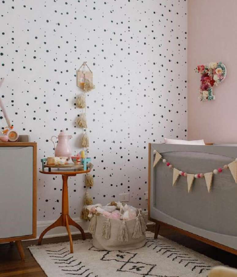 12. Mesa de canto para quarto de bebê decorado com papel de parede de bolinhas e berço cinza – Foto: MamãeAchei!