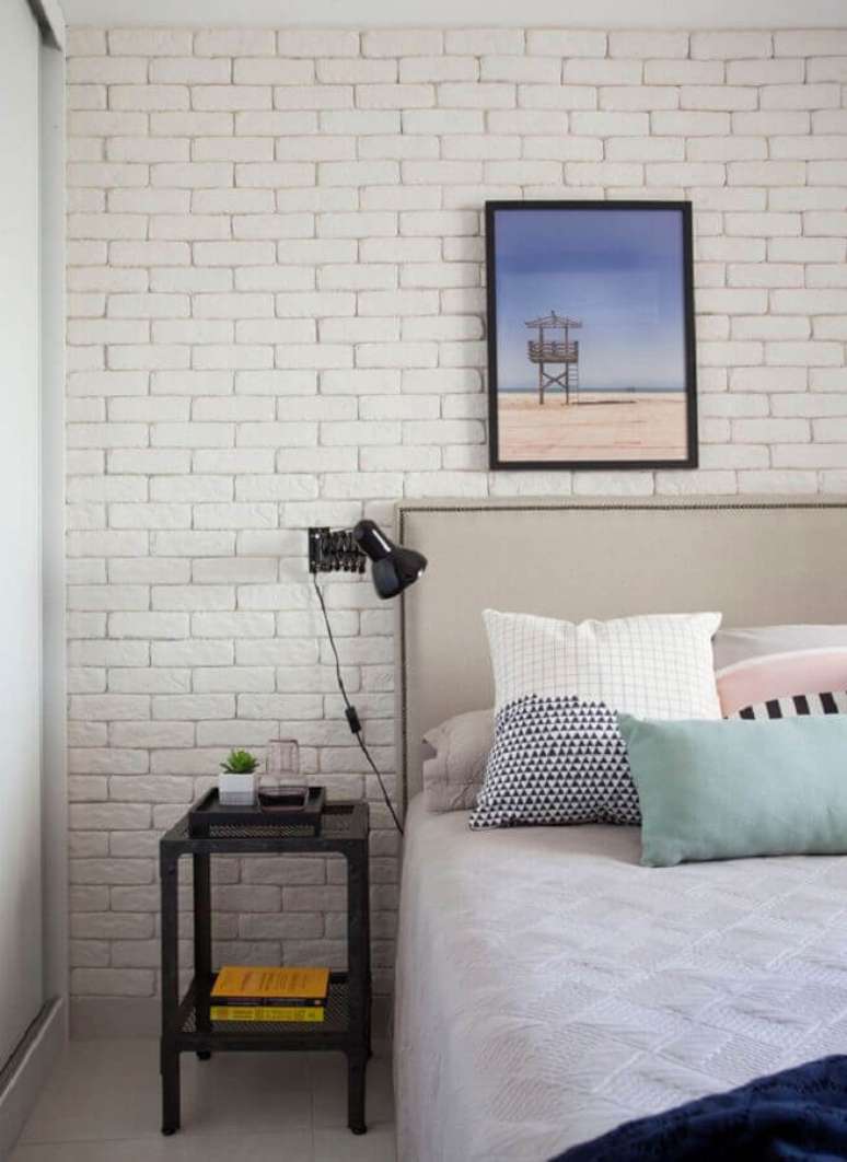 35. Mesa de canto para quarto de casal decorado com parede de tijolinho branca – Foto: Archilovers