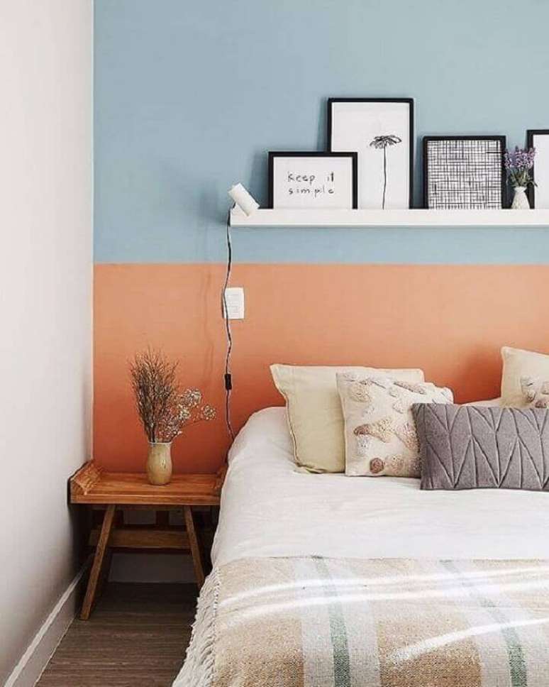 50. Mesa de canto de madeira para decoração de quarto simples com parede na cor coral e azul – Foto: A Casa Delas