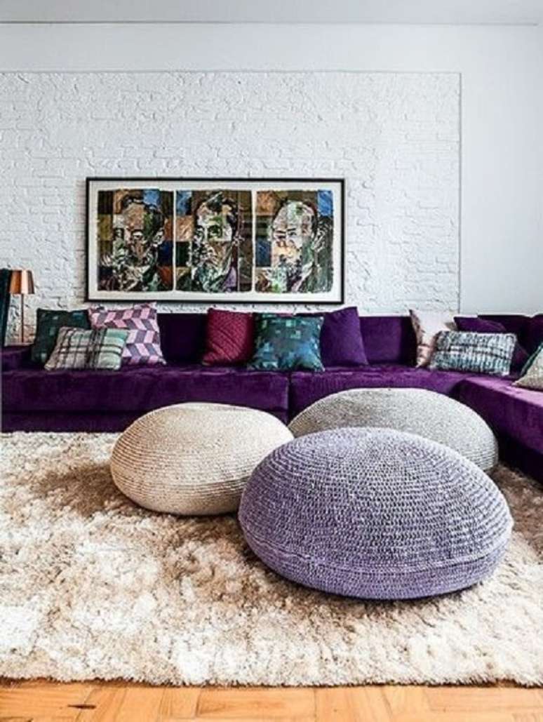 33. O sof&aacute; de canto roxo acomoda v&aacute;rias pessoas no ambiente. Fonte: Pinterest