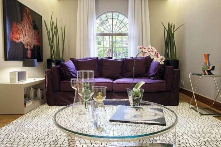 31. O sofá roxo contrasta com as cores claras das paredes e tapete da sala de estar. Fonte: Deborah Basso