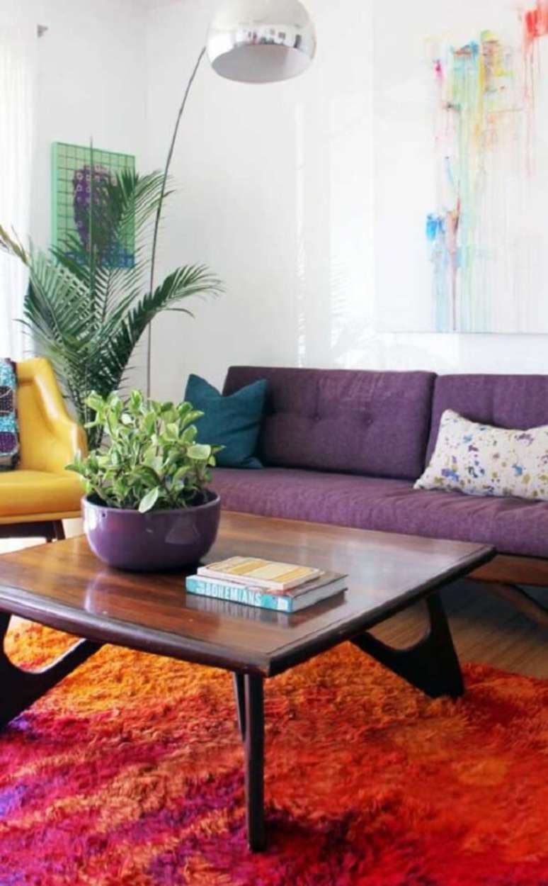 5. Ouse na decora&ccedil;&atilde;o e aposte na combina&ccedil;&atilde;o entre tapete laranja e sof&aacute; roxo. Fonte: Pinterest