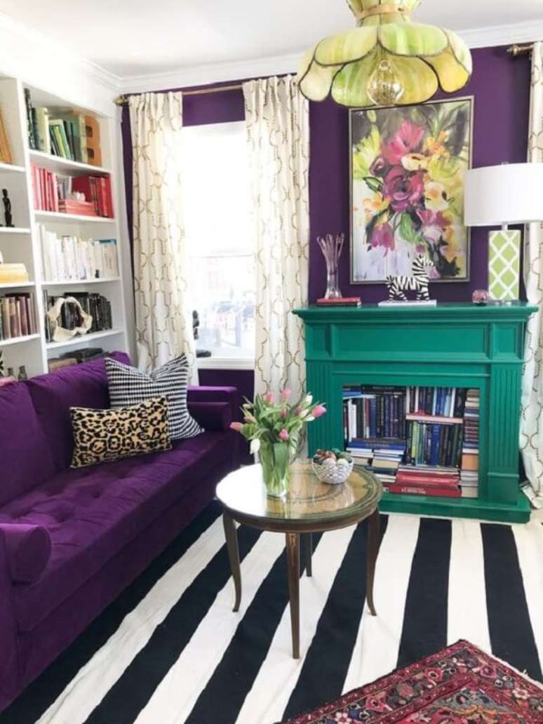 60. Sofá roxo escuro com tapete listrado decoram o espaço. Fonte: Pinterest