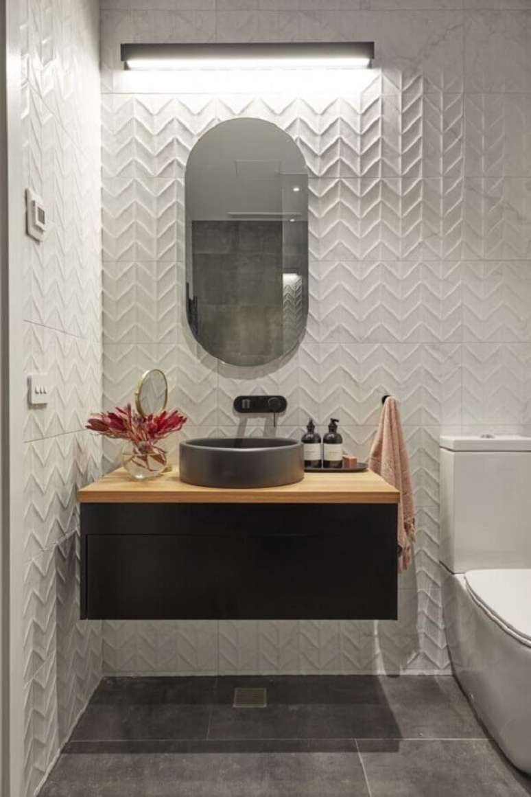 11. Revestimento branco para banheiro decorado com gabinete preto suspenso – Foto: Beaumont Tiles