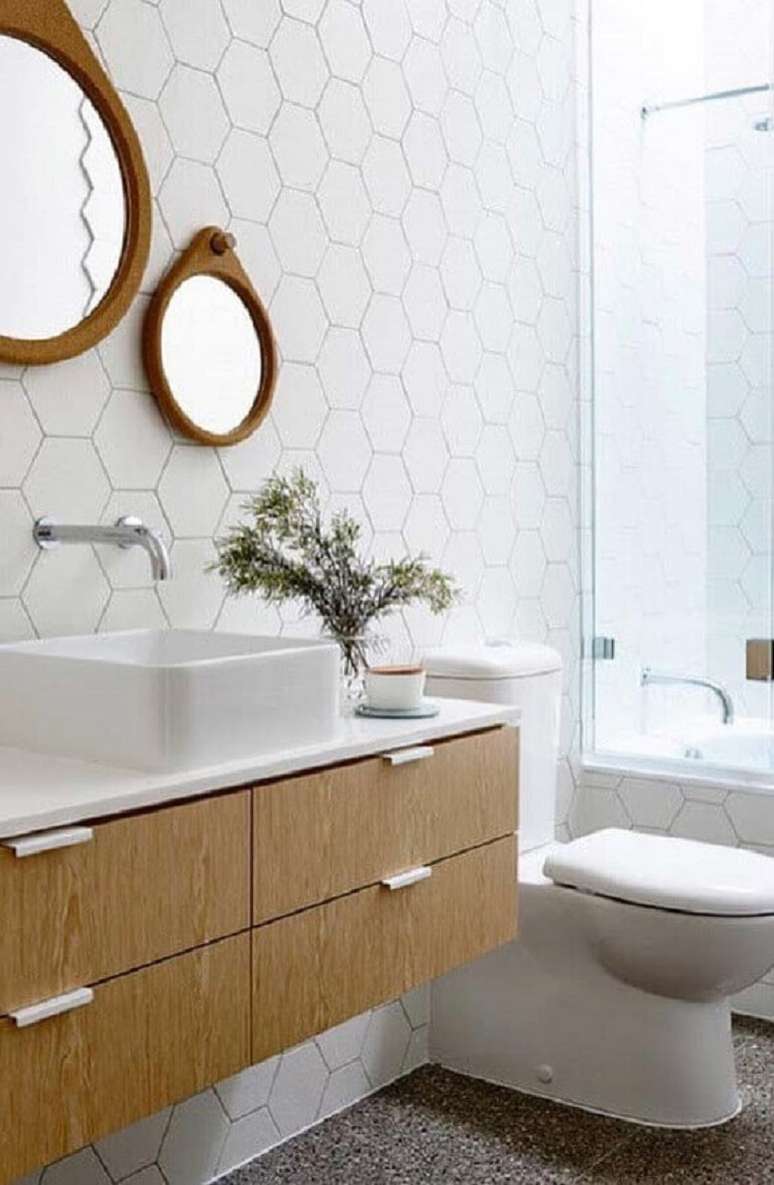 55. Decora&ccedil;&atilde;o com revestimento hexagonal branco para banheiro com gabinete e espelhos de madeira &ndash; Foto: Apartment Therapy