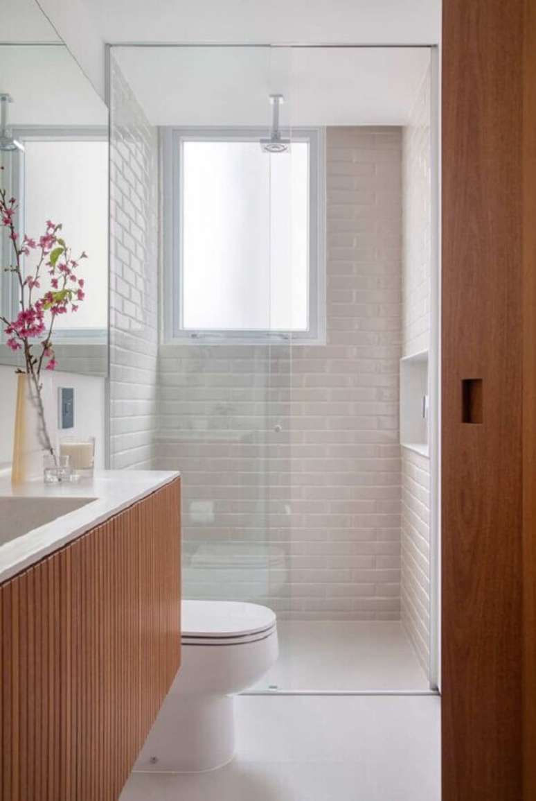 44. Revestimento branco para banheiro pequeno decorado com gabinete de madeira – Foto: Casa de Valentina