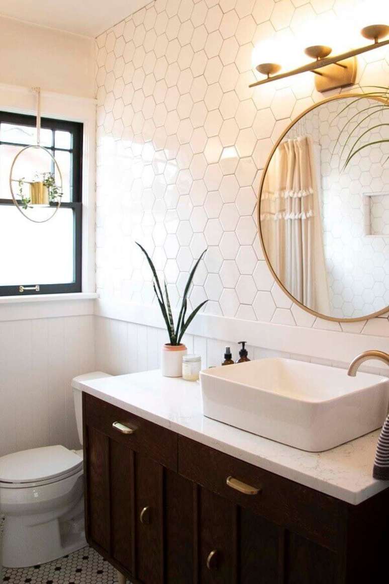 56. Revestimento hexagonal branco para banheiro decorado com espelho redondo – Foto: Apartment Therapy