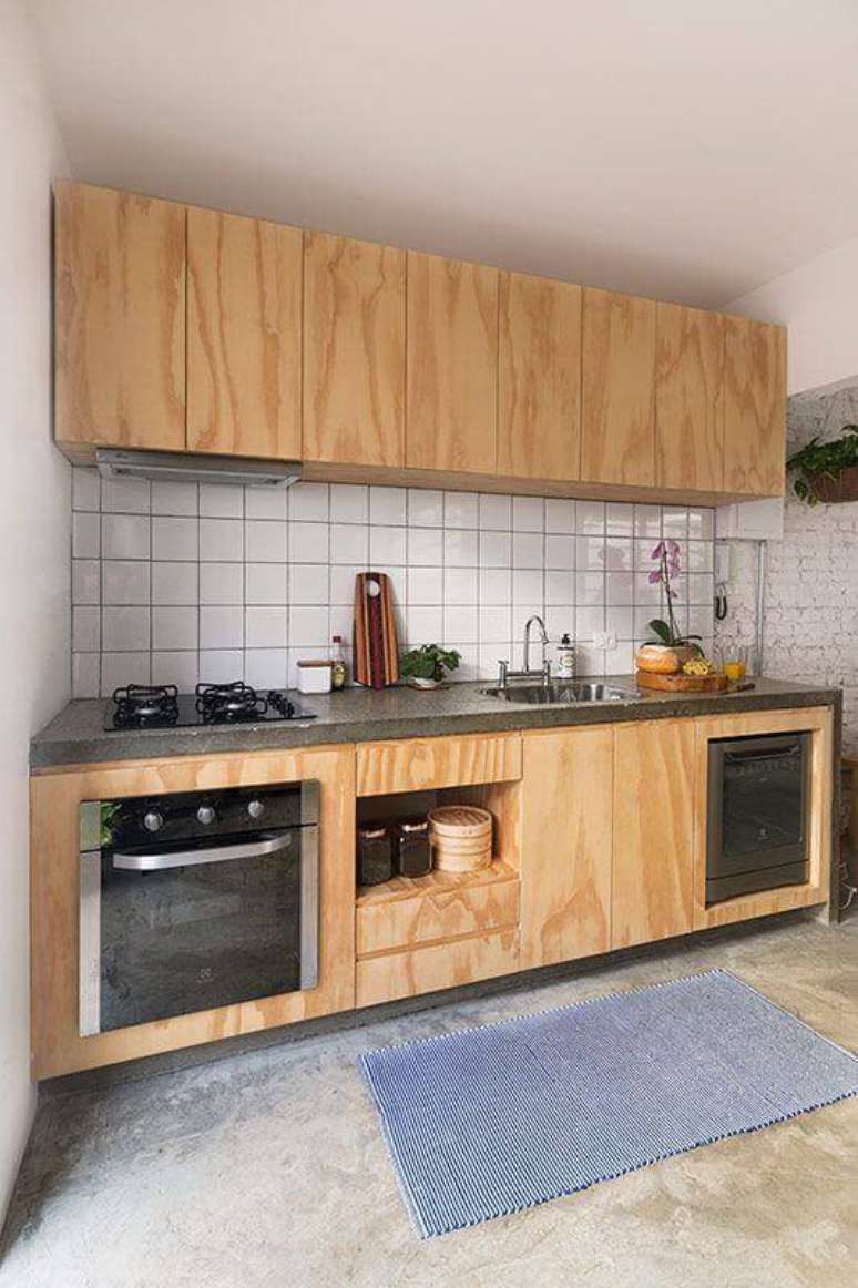 46. Decoração simples para cozinha com revestimento branco e armário de madeira – Foto: INÁ Arquitetura