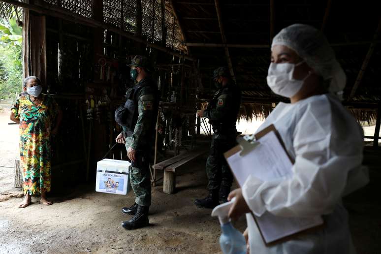 Profissional de sa&uacute;de e policial militar conversam com ind&iacute;gena no Amazonas
 9/2/2021   REUTERS/Bruno Kelly