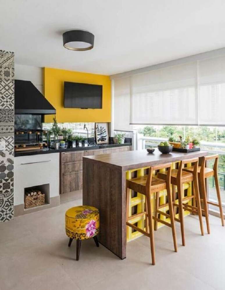 11. Bancada e banquetas de madeira para &aacute;rea gourmet planejada com churrasqueira de vidro &ndash; Foto: Home Fashion Trend