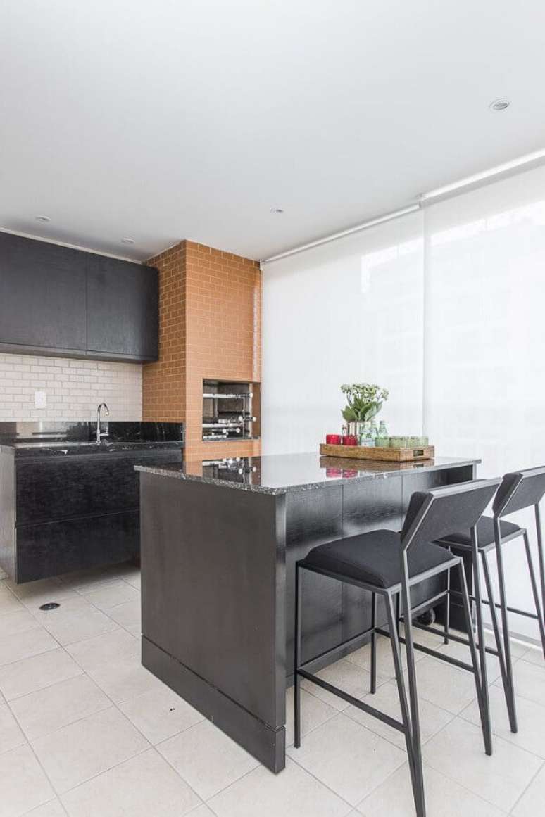 22. Banqueta para &aacute;rea gourmet simples decorada com m&oacute;veis pretos e churrasqueira tijolinho &ndash; Foto: Spaze Arquitetura e Inteiores