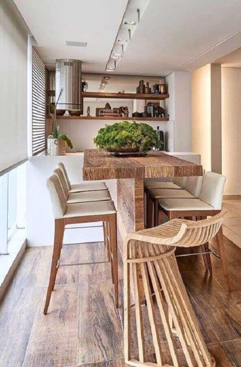7. Banquetas altas para &aacute;rea gourmet decorada com mesa r&uacute;stica de madeira &ndash; Foto: Arkpad