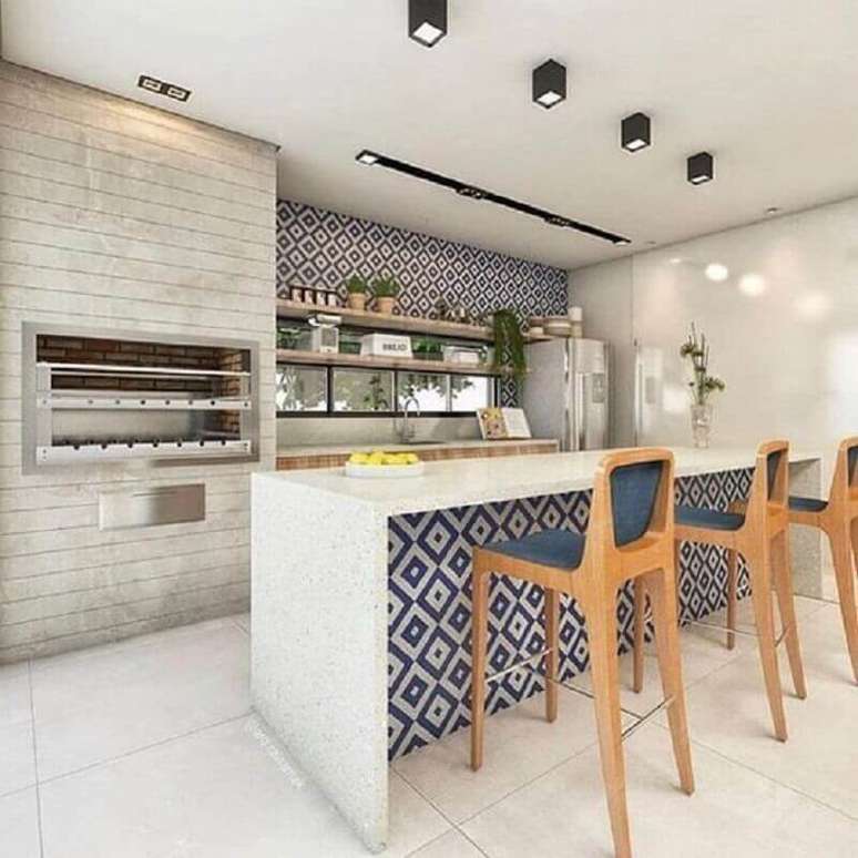 23. Banquetas de madeira para &aacute;rea gourmet decorada com churrasqueira grande e revestimento geom&eacute;trico azul &ndash; Foto: Pinterest