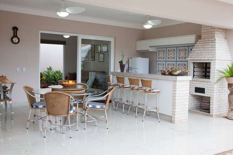 50. Cadeiras e banquetas para &aacute;rea gourmet ampla decorada com churrasqueira de tijolinho &ndash; Foto: Fantin Siqueira
