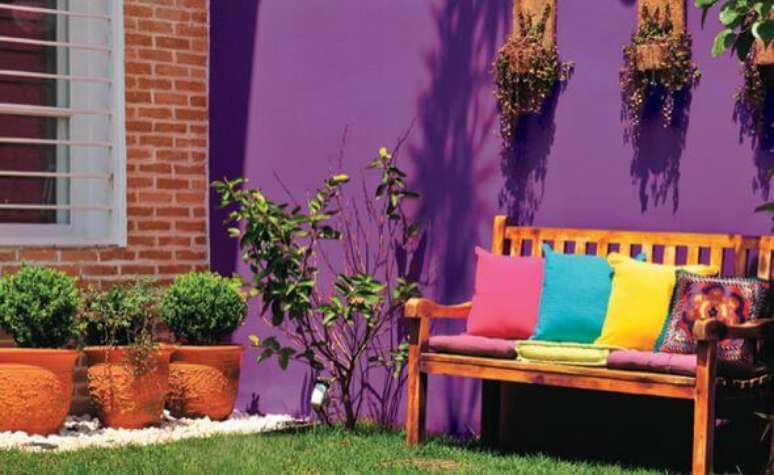 16. Jardim com parede roxa e móveis coloridos – Via: Pinterest
