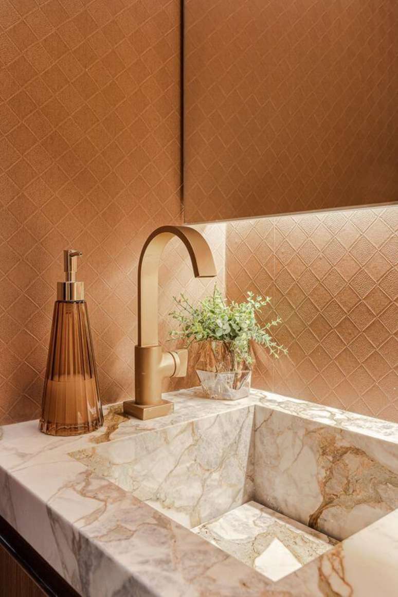1. Banheiro luxuoso com cuba de mármore e detalhes em dourado – Via: ARD Studio