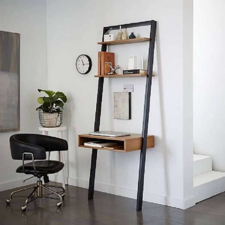 62. A cadeira preta giratória serve de acesso para a escrivaninha de ferro e madeira. Fonte: West Elm
