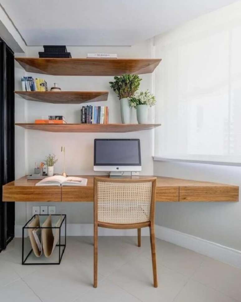5. Escrivaninha de madeira suspensa de canto é uma ótima alternativa para espaços pequenos. Projeto por GAM Arquitetos
