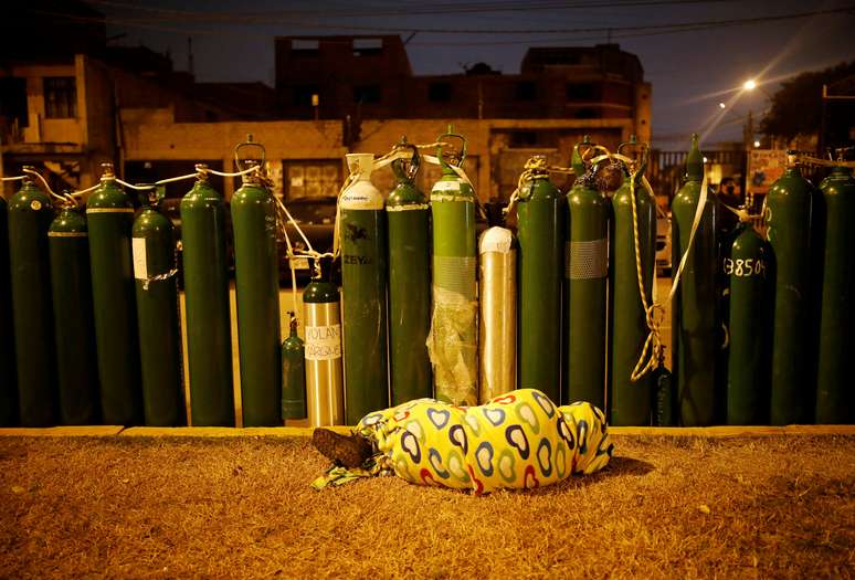 Pessoa dorme ao lado de cilindros vazios de oxigênio para guardar lugar na fila de reabastecimento em Callao, no Peru
04/02/2020
REUTERS/Sebastian Castaneda