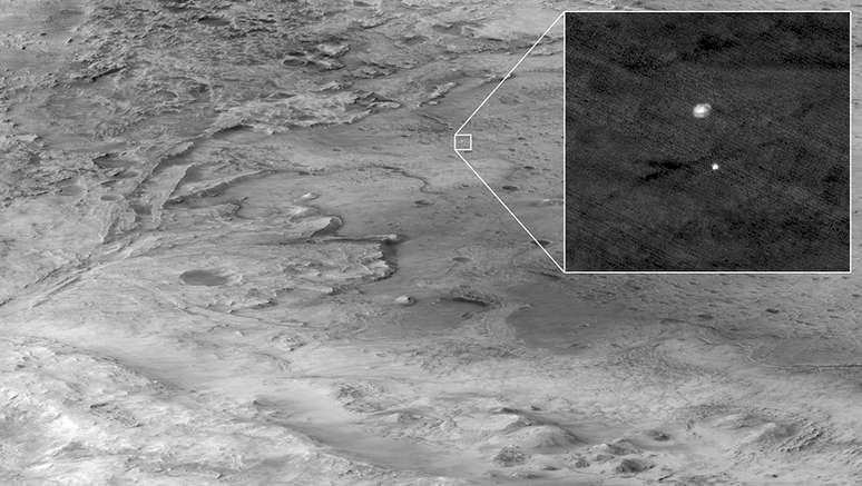 Na imagem ampliada, a Perseverance pode ser vista descendo para a cratera Jazero com a ajuda de um paraquedas.