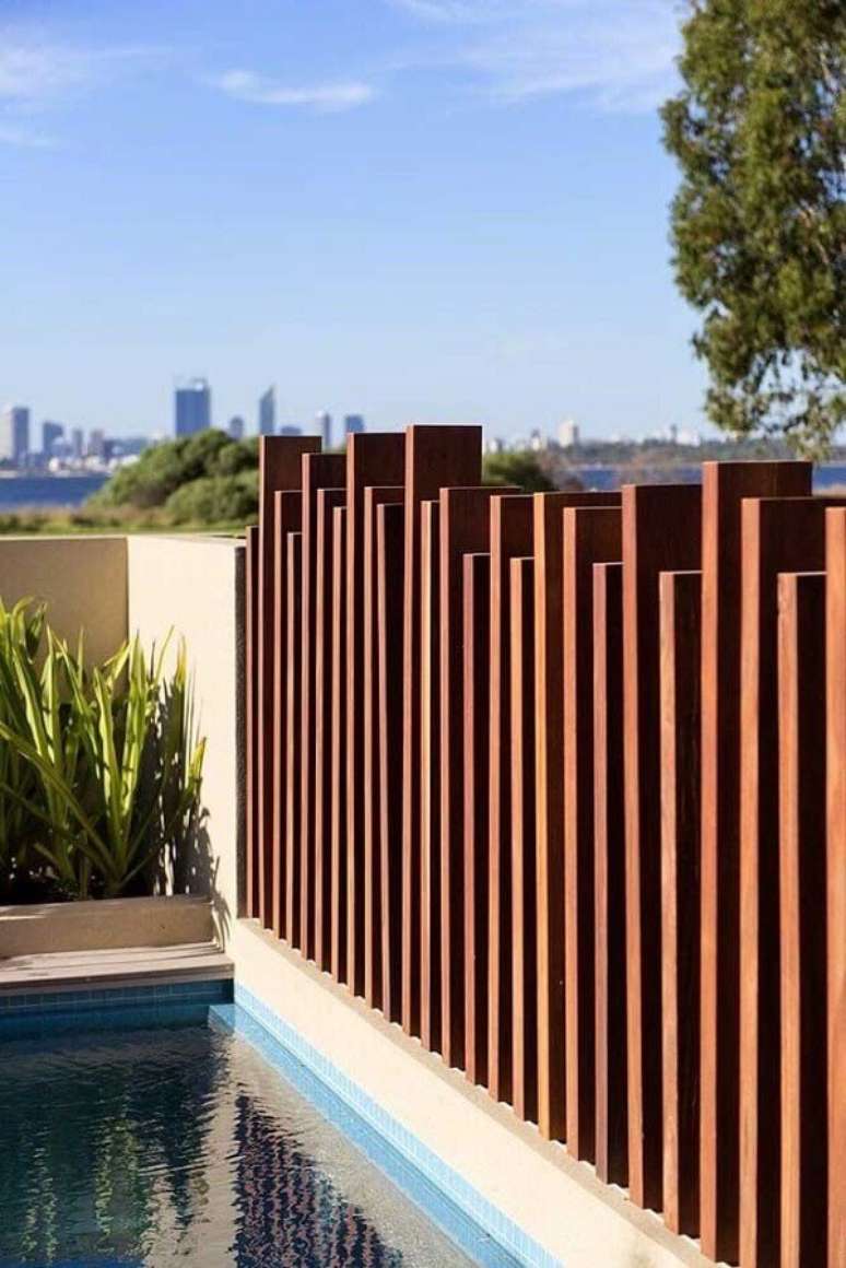 61. Modelo de muro moderno feito em madeira traz privacidade para a área da piscina. Fonte: Pinterest