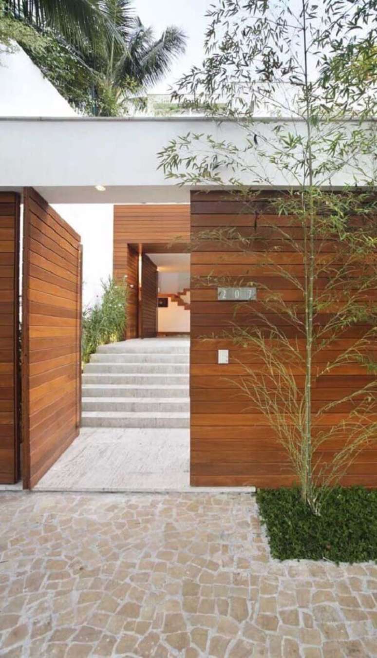 50. Modelo de muro de frente de casa feito em madeira é durável e traz segurança ao imóvel. Fonte: Pinterest