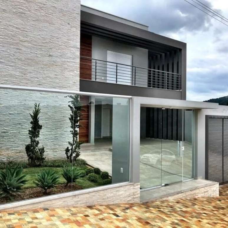 72. O modelo de frente de muro feito em vidro traz charme para a fachada da casa. Fonte: Ramsine Kézia Arquitetura