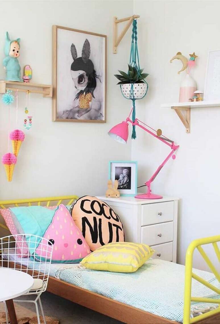 21. Decoração simples de quarto para criança menina com almofadas divertidas e luminária cor de rosa – Foto: Pinterest