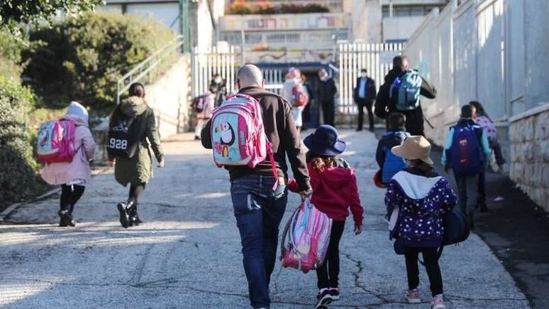 Comportamento de adultos pode influenciar a segurança sanitária dentro de escolas; acima, crianças chegando à escola em Jerusalém, em 21 de fevereiro