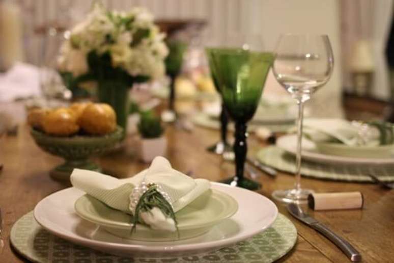 49- A mesa posta para jantar tem taças, pratos de sobremesa e sousplat em tons verde. Fonte: Patricia Junqueira