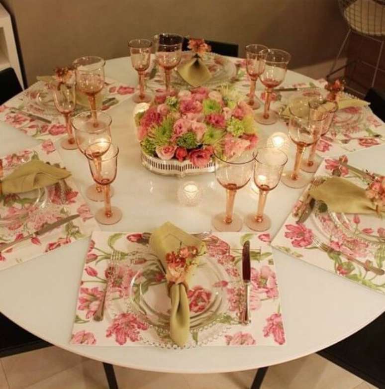 54- O arranjo no centro da mesa tem flores em tons rosa iguais ao tecido do jogo americano. Fonte: Blog Maiara Costa