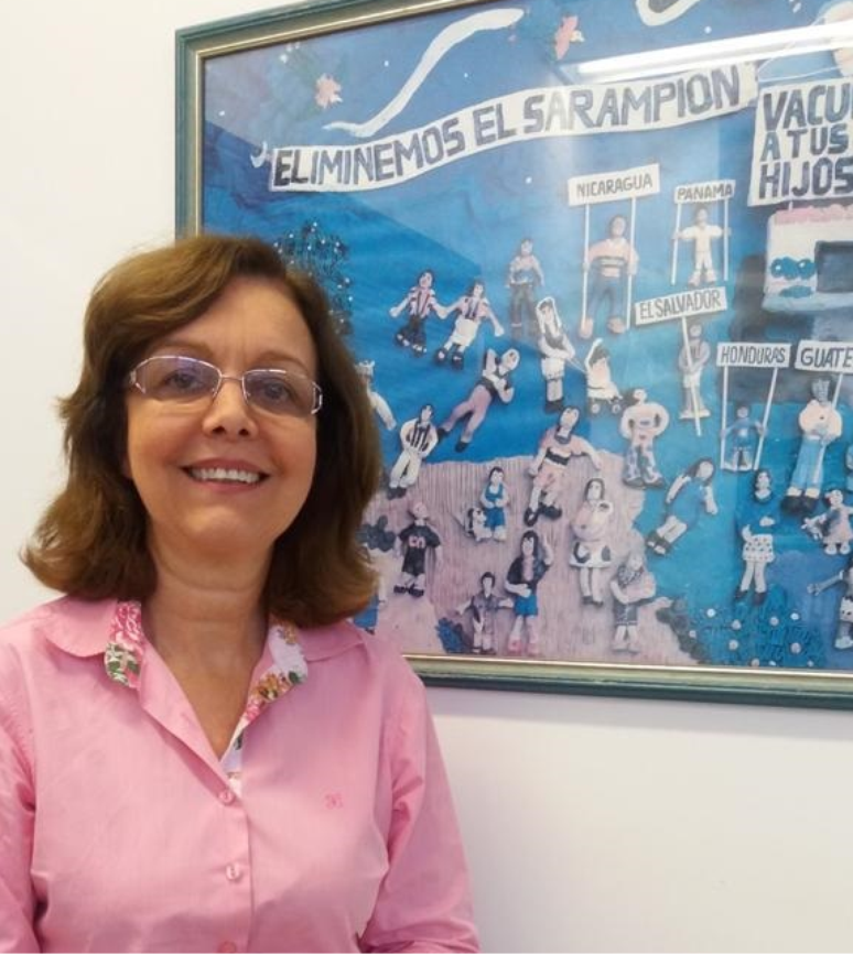 Marilda com quadro da campanha contra sarampo que fica em sua sala: 'Brasil foi luz no fim do túnel para outros países'