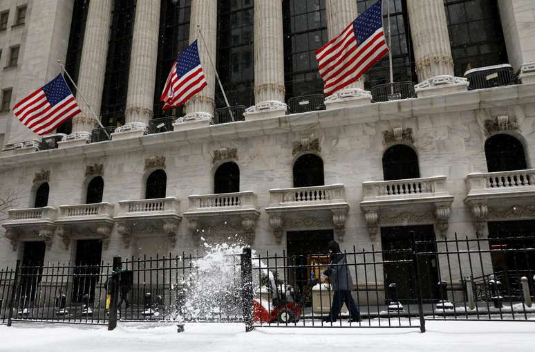 Trabalhadores limpam a neve de uma calçada do lado de fora da Bolsa de Valores de Nova York (NYSE) durante uma tempestade de neve em Manhattan, EUA, 18 de fevereiro de 2021. REUTERS/Brendan McDermid
