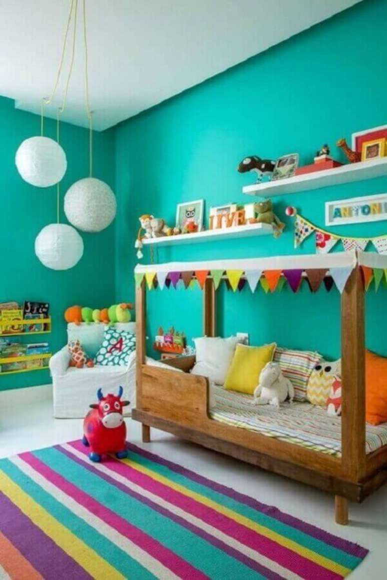 5. Parede cor verde água para decoração de quarto infantil com tapete listrado colorido – Foto NaToca Designs