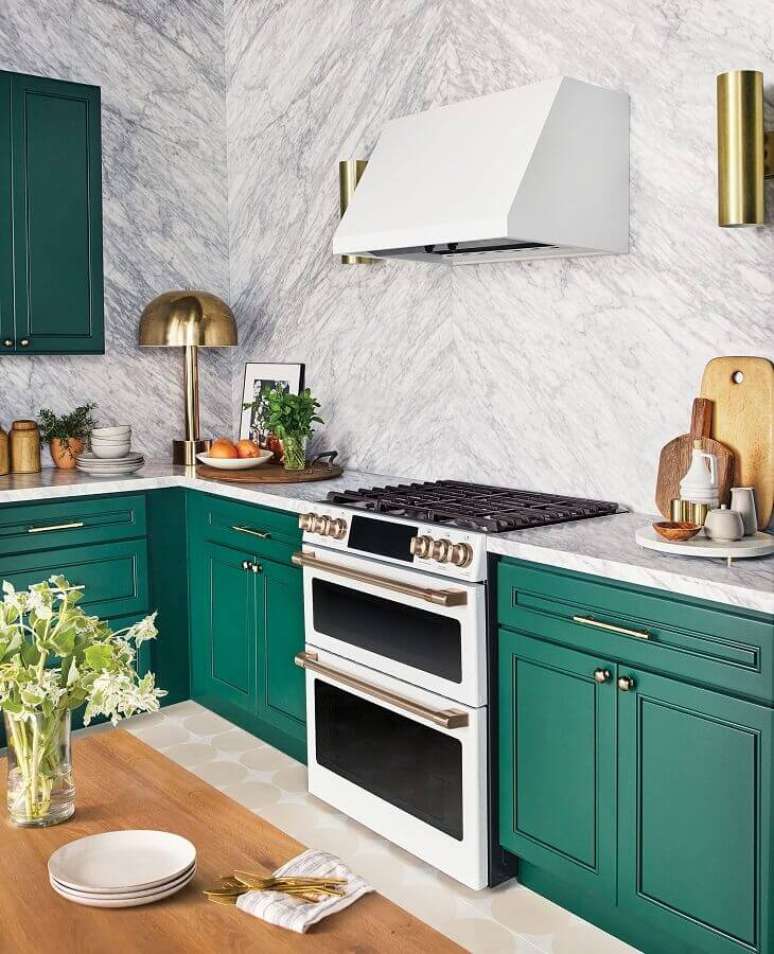 9. Decoração de cozinha com revestimento de mármore e armário planejado na cor verde esmeralda com puxadores dourados – Foto Sugar and Charm