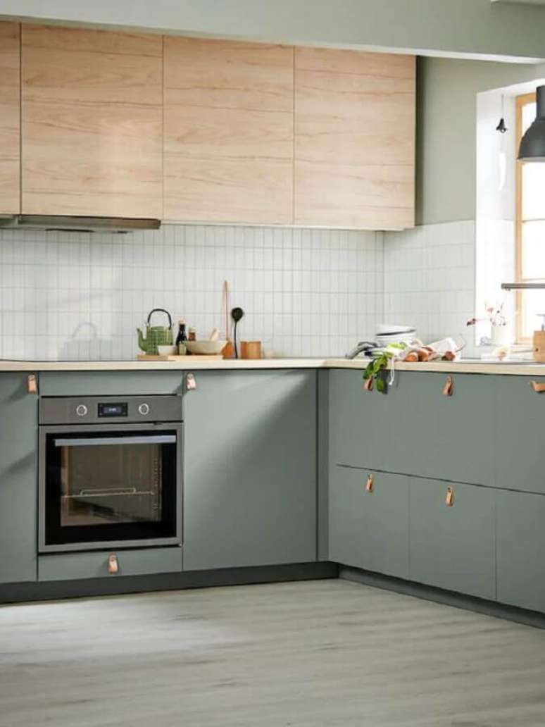 26. Decoração de cozinha moderna com armário aéreo de madeira e gabinete na cor verde claro – Foto Apartment Therapy