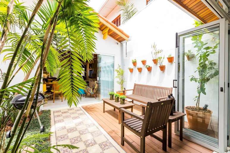 14. Terra&ccedil;o aberto decorado com piso de madeira e azulejo antigo. Projeto BY Arq&Design