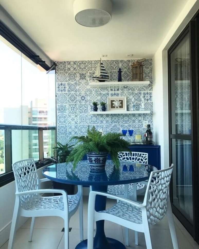 11. Varanda com móveis em tom de azul que se conectam com os azulejos antigos. Fonte: Arkpad