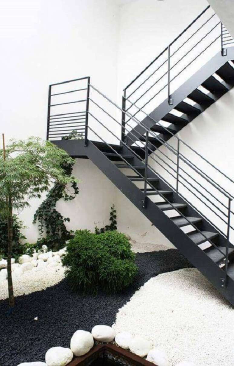 52. Que tal integrar um lindo jardim externo próximo ao revestimento para escada de ferro? Fonte: Pinterest