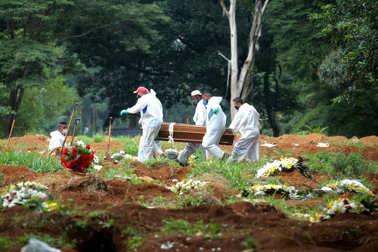 Coveiros com trajes de proteção carregam caixão de mulher que morreu de Covid-19, no cemitério de Vila Formosa, em São Paulo
09/03/2021
REUTERS/Carla Carniel