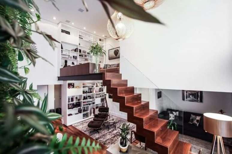 69. Modernidade e leveza com esse revestimento de escada em madeira com guarda corpo de vidro. Fonte: Pinterest