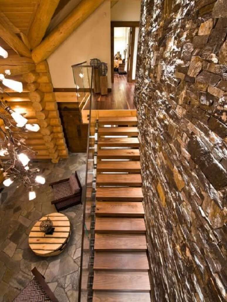 66. Decoração rústica com parede de pedra e revestimento para escada em madeira. Fonte: Pinterest