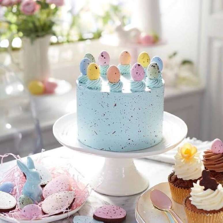 11. Modelo de bolo de Páscoa azul decorado com mini ovinhos coloridos no topo – Foto: Deavita